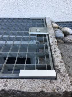 Bei einem Gitterrost mit Sicherung wird ein Profilstück unterlegt, um die Höhe auszugleichen